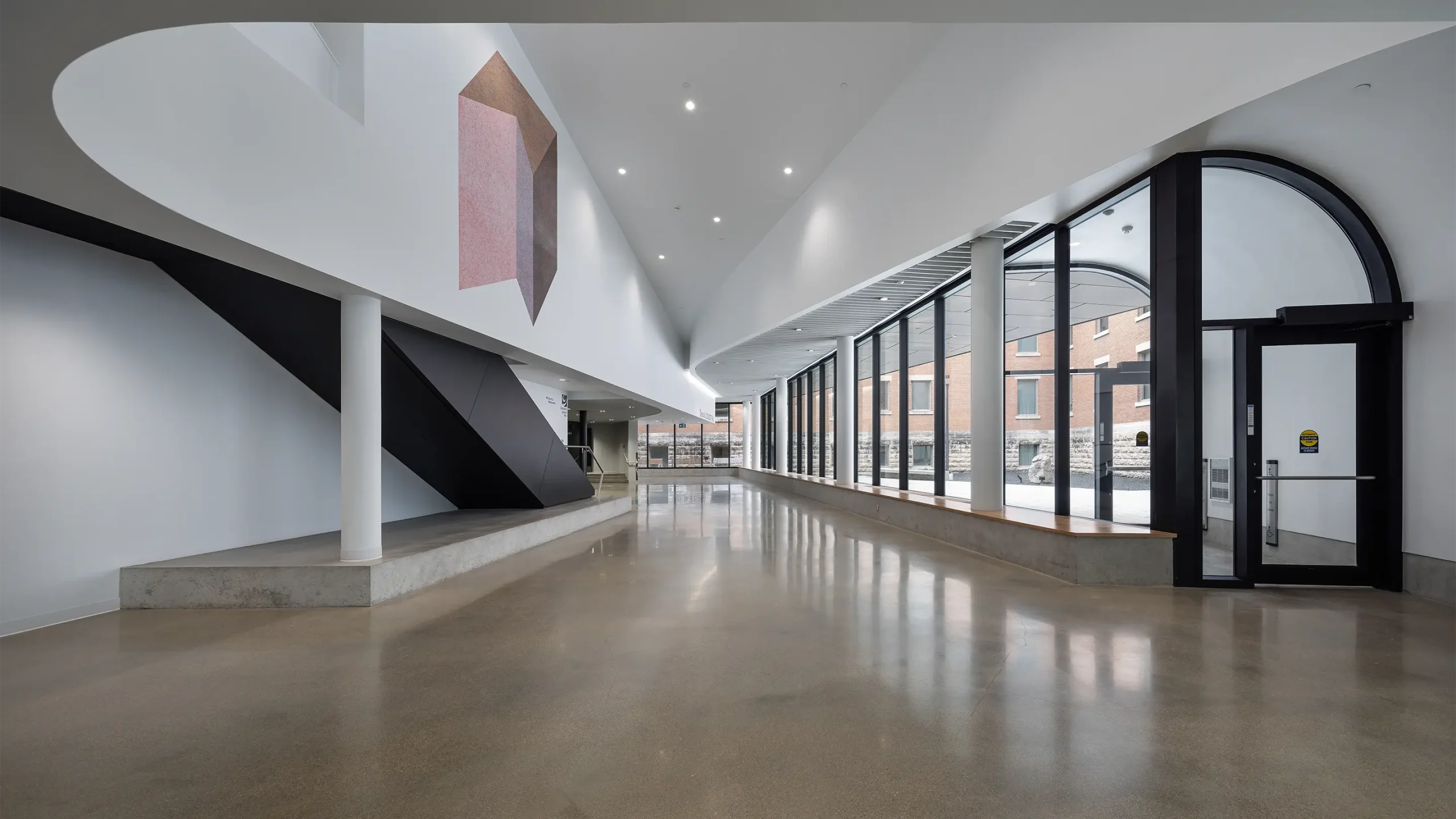Interior hallway showcasing wall of exterior, ground level windows