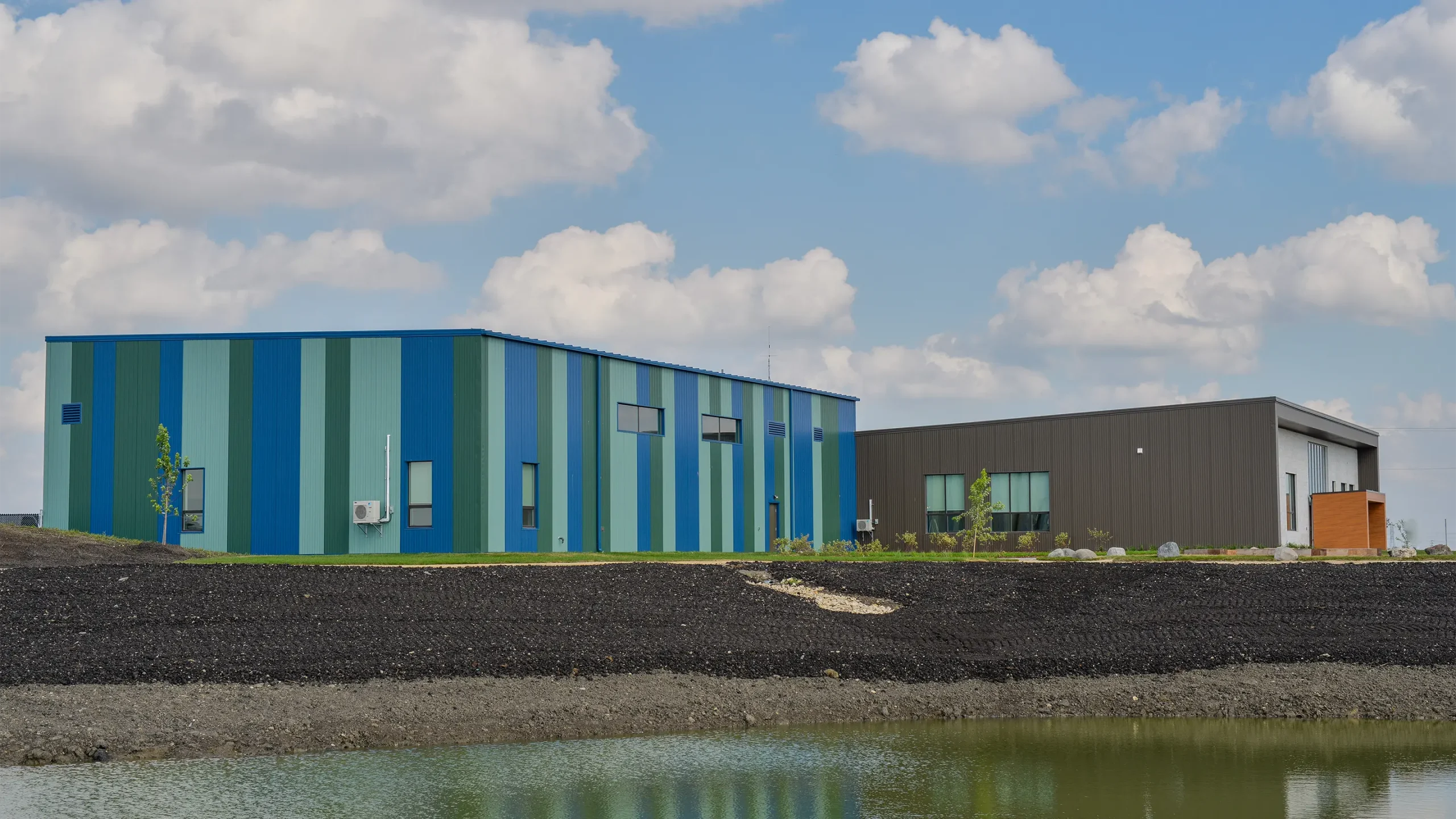 3D architectural render of building showing stormwater retention pond