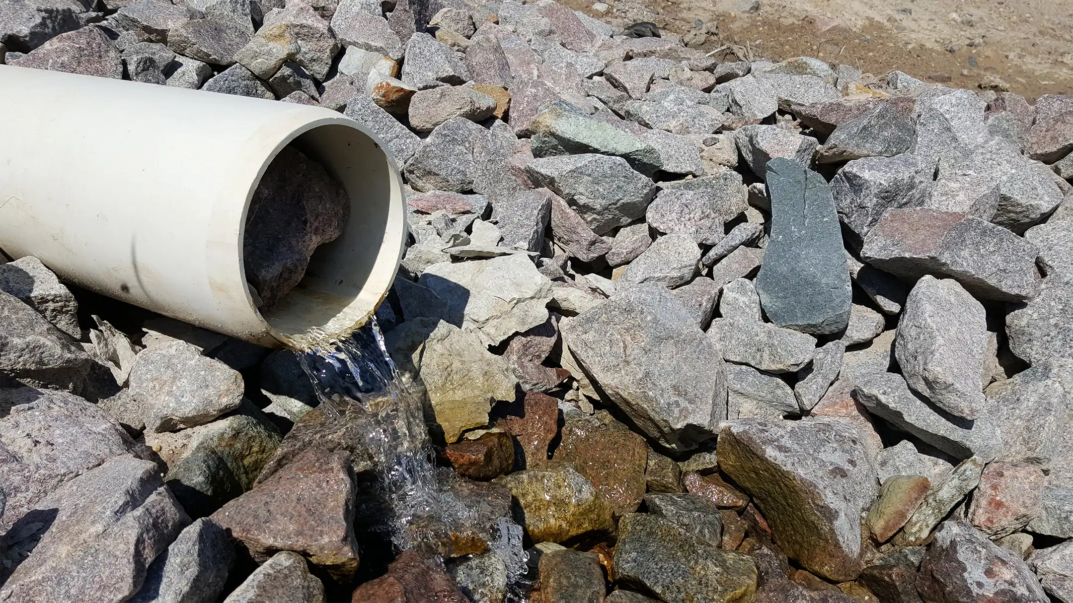 Drainage via pipe onto rocks