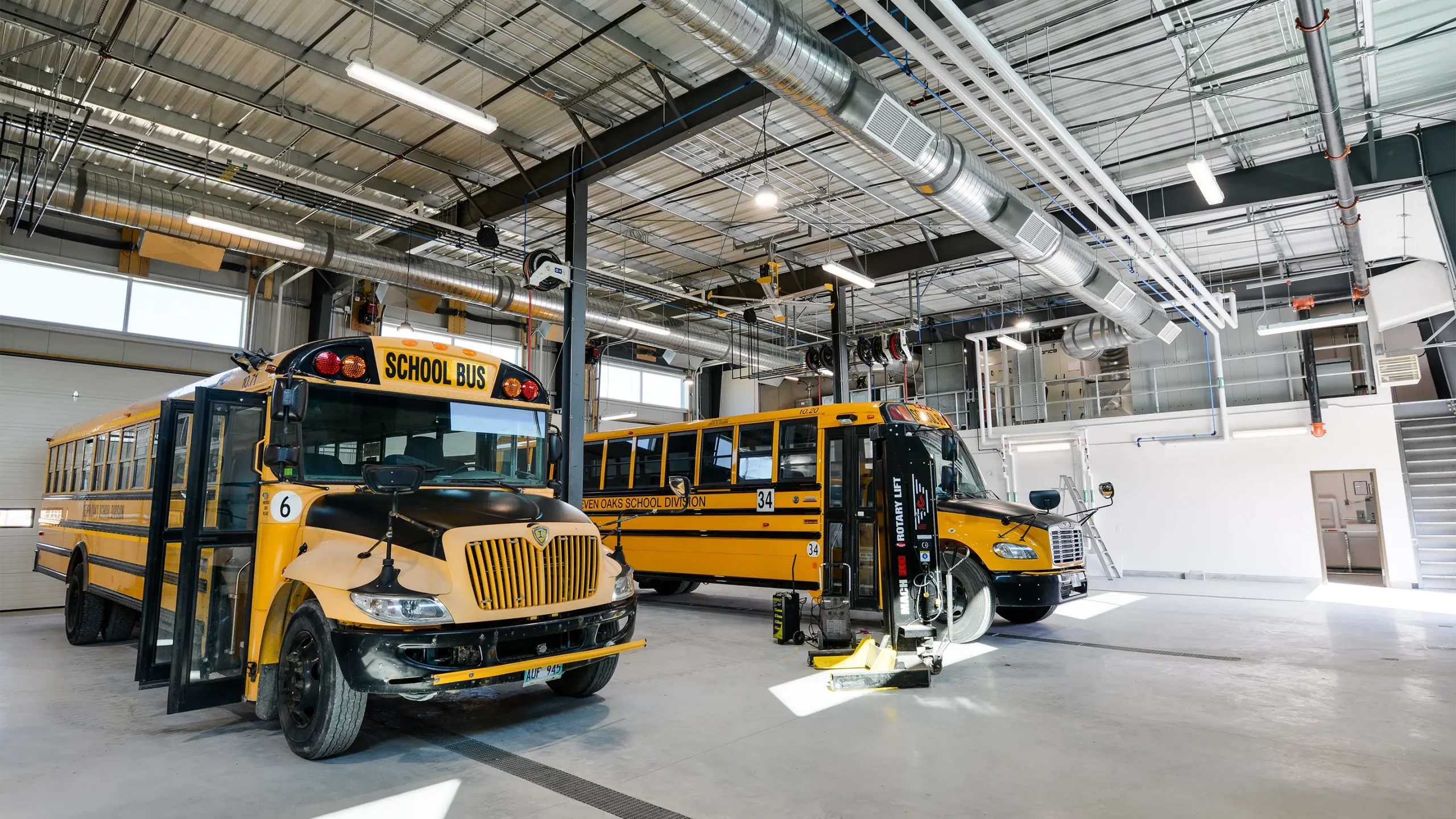 Two school busses parked inside facility