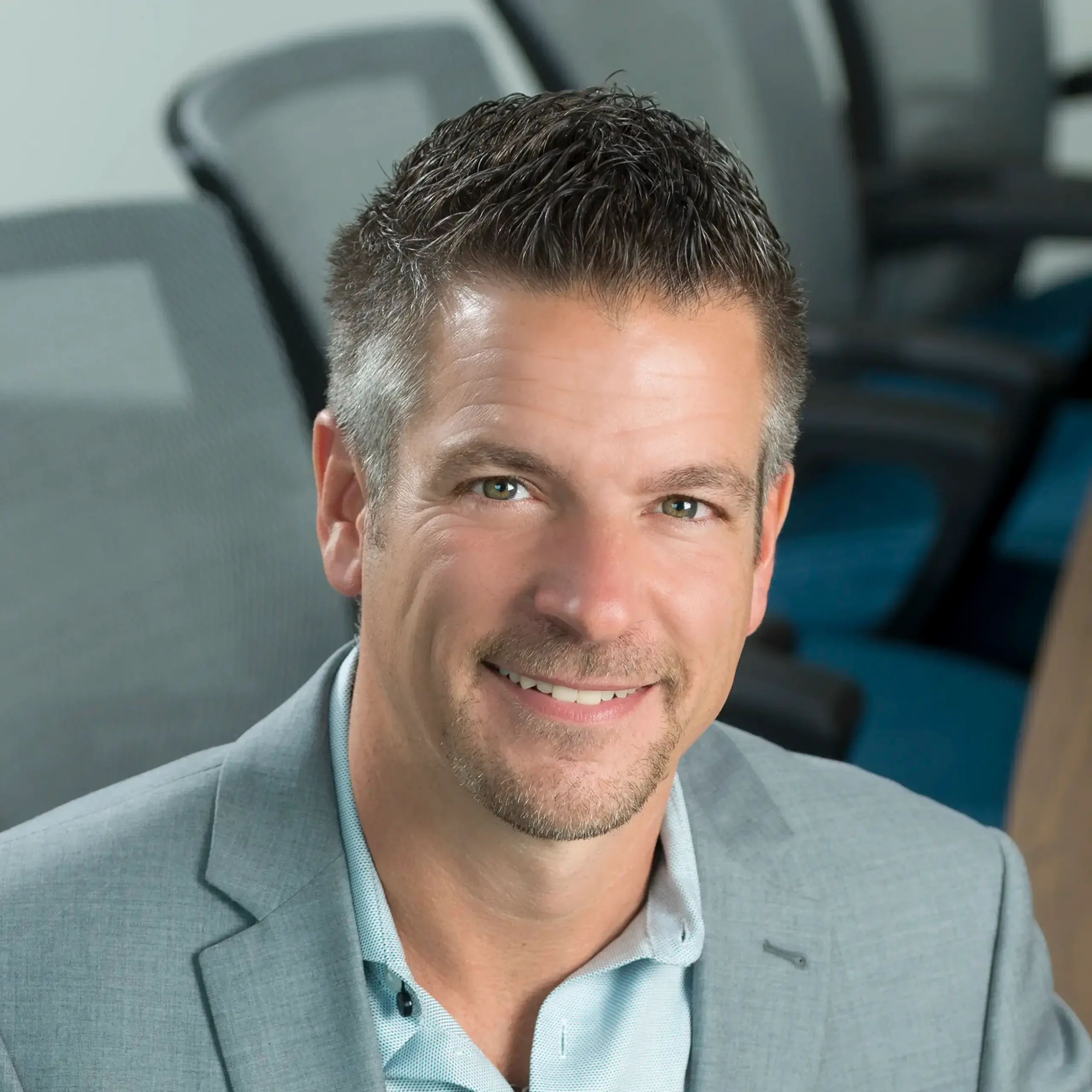 Colin Siepman smiles warmly while sitting in an office setting.