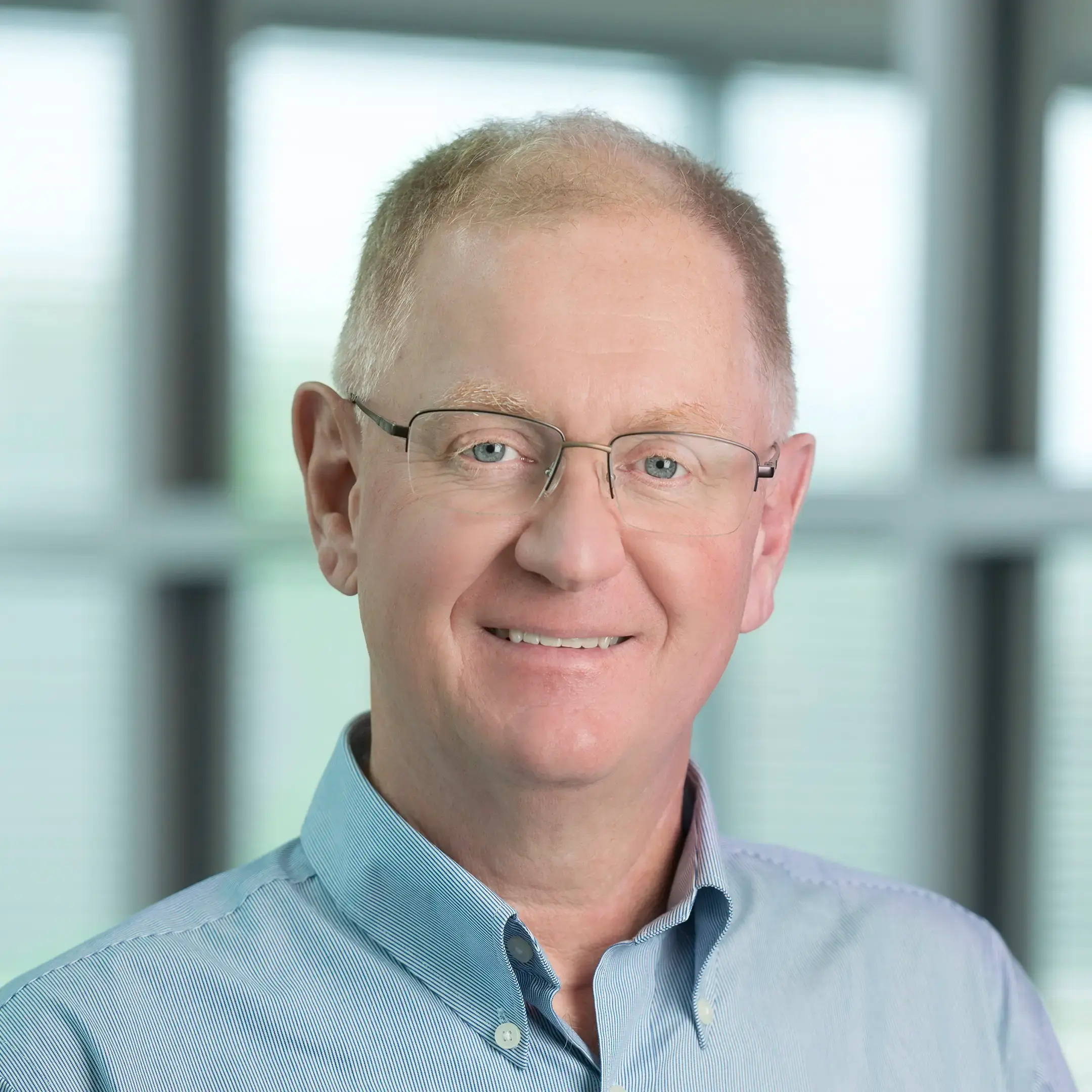 Gord McPhail smiles warmly while standing in an office setting.