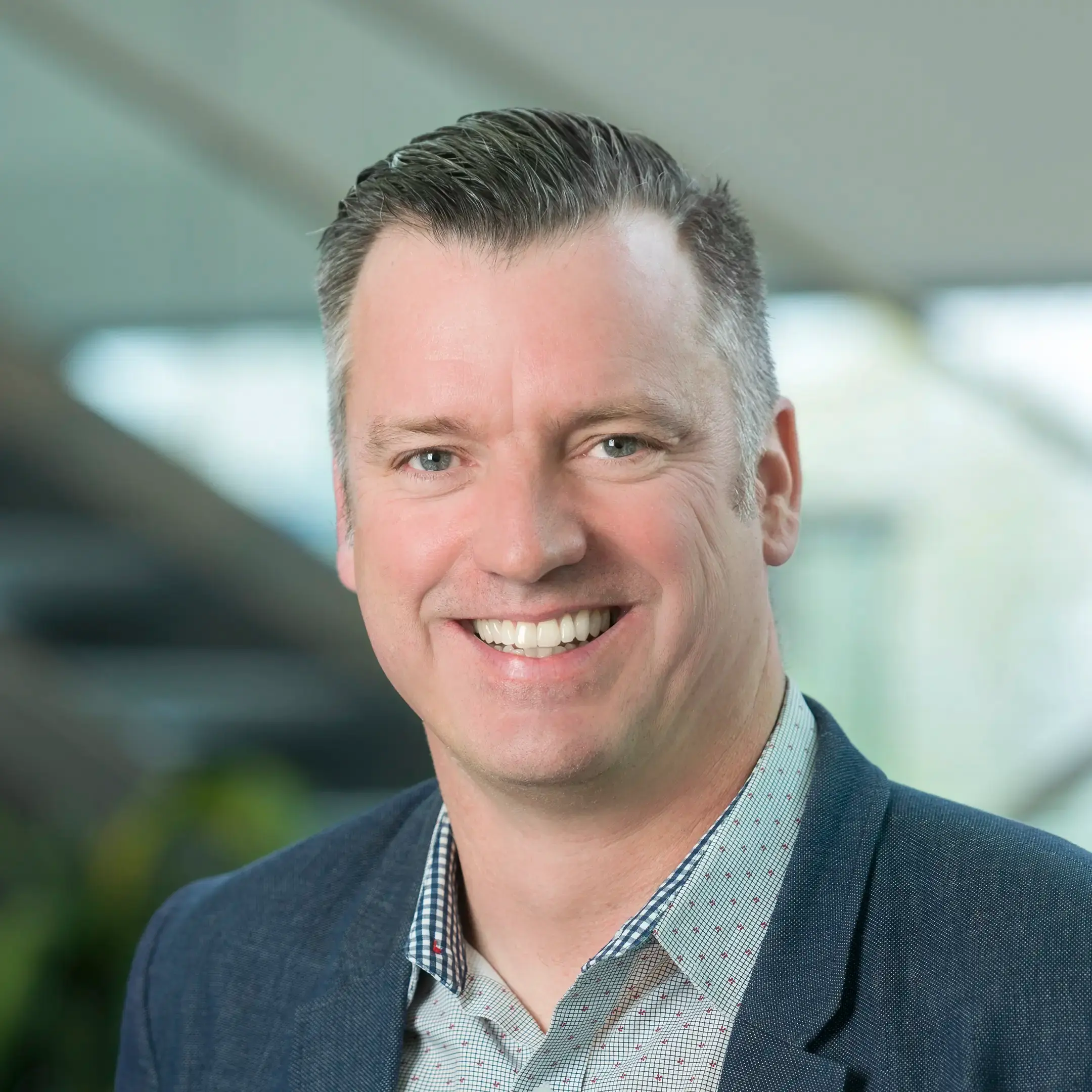 Jason Mann smiles confidently while standing in an office setting.