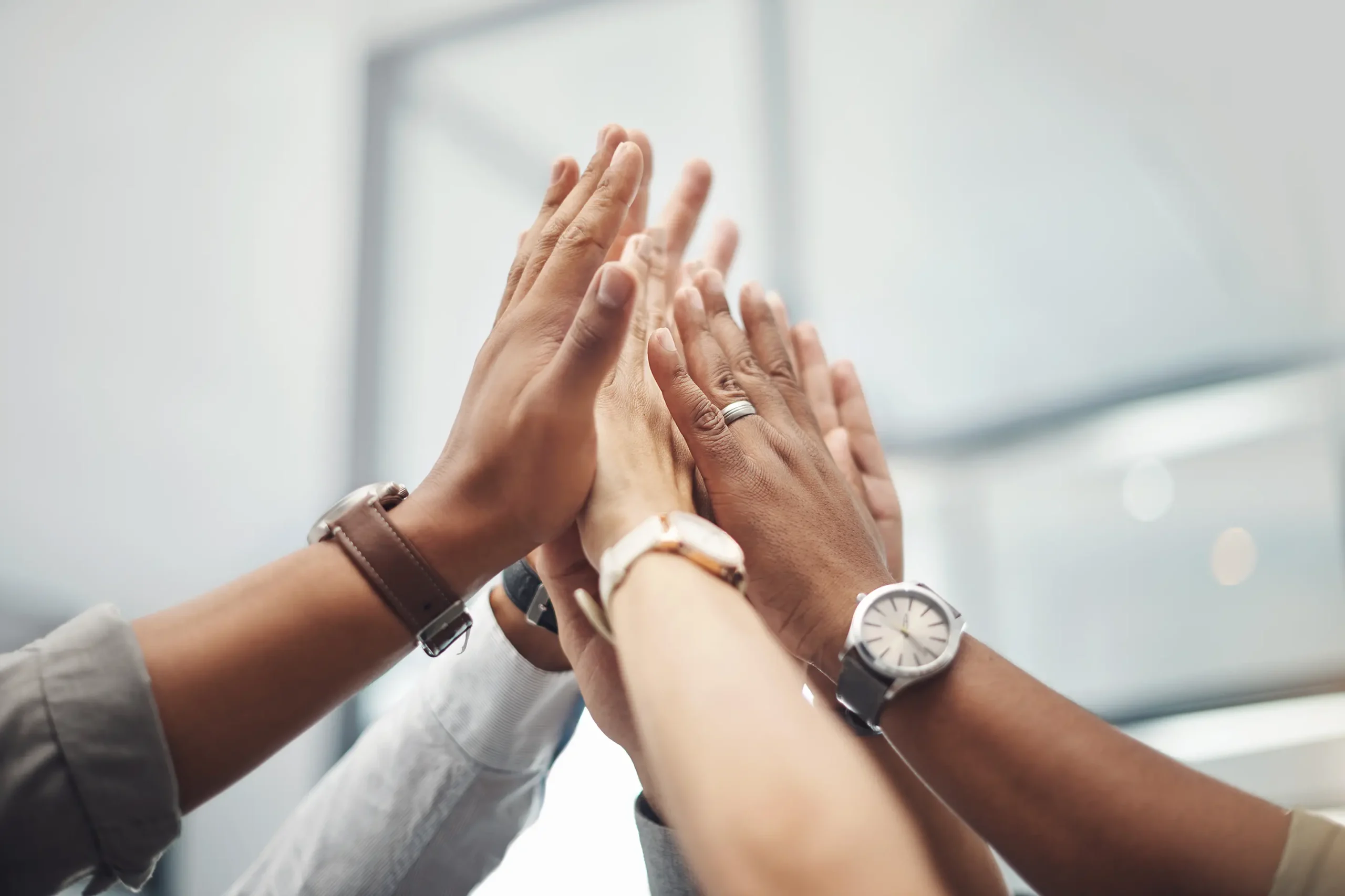 A group of hands coming together for a high‑five.