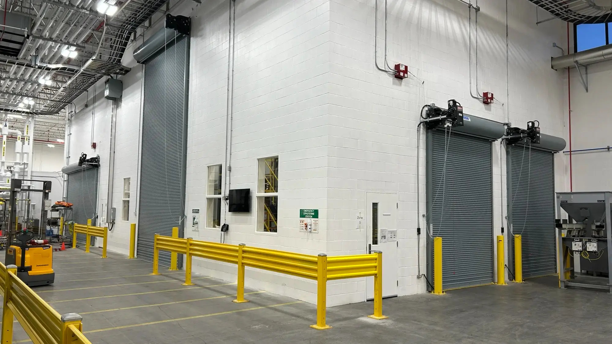 Two large vehicle doors installed on the exterior of the furnace room