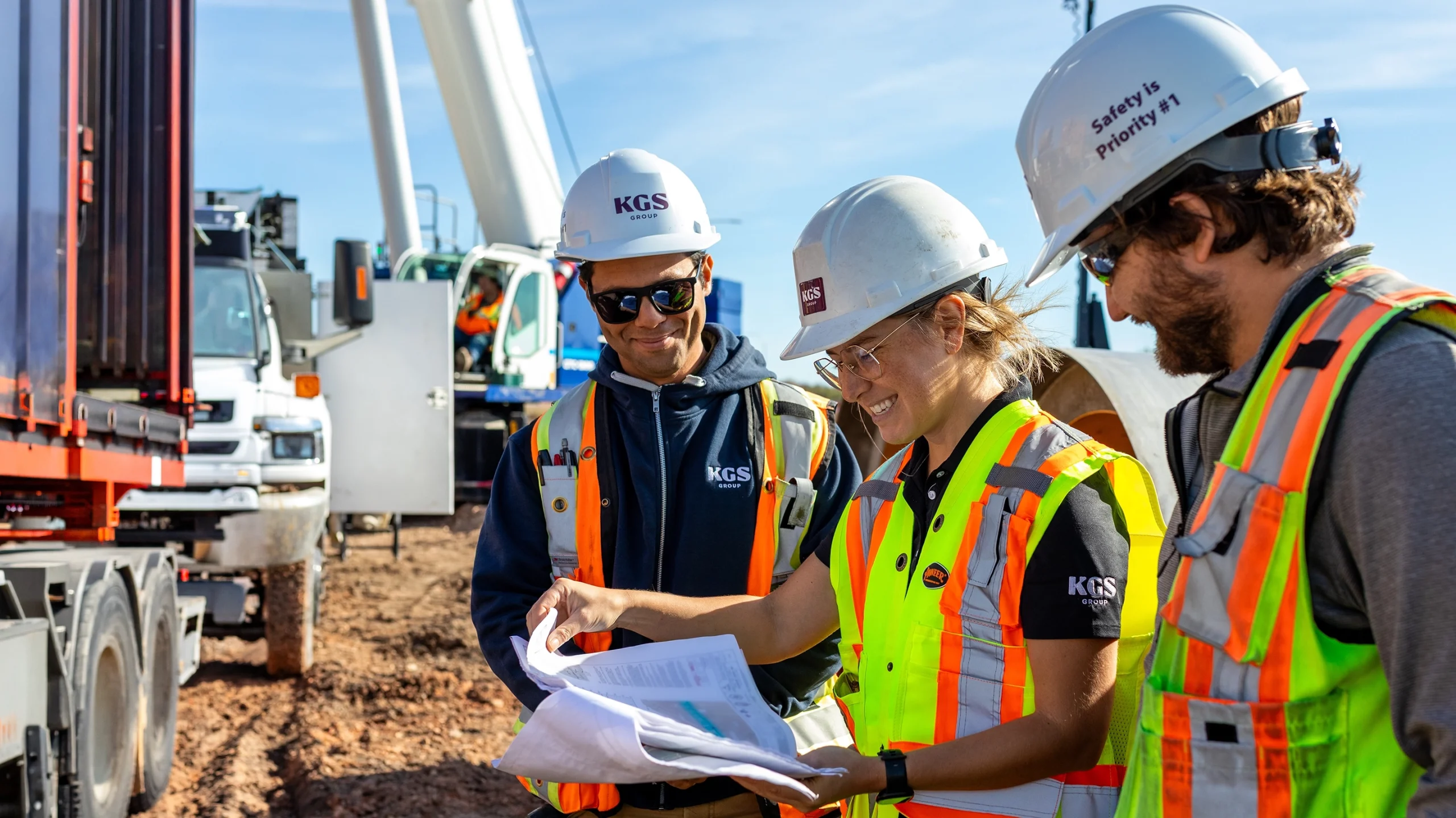 Three engineers reviewing drawings on a construction site
