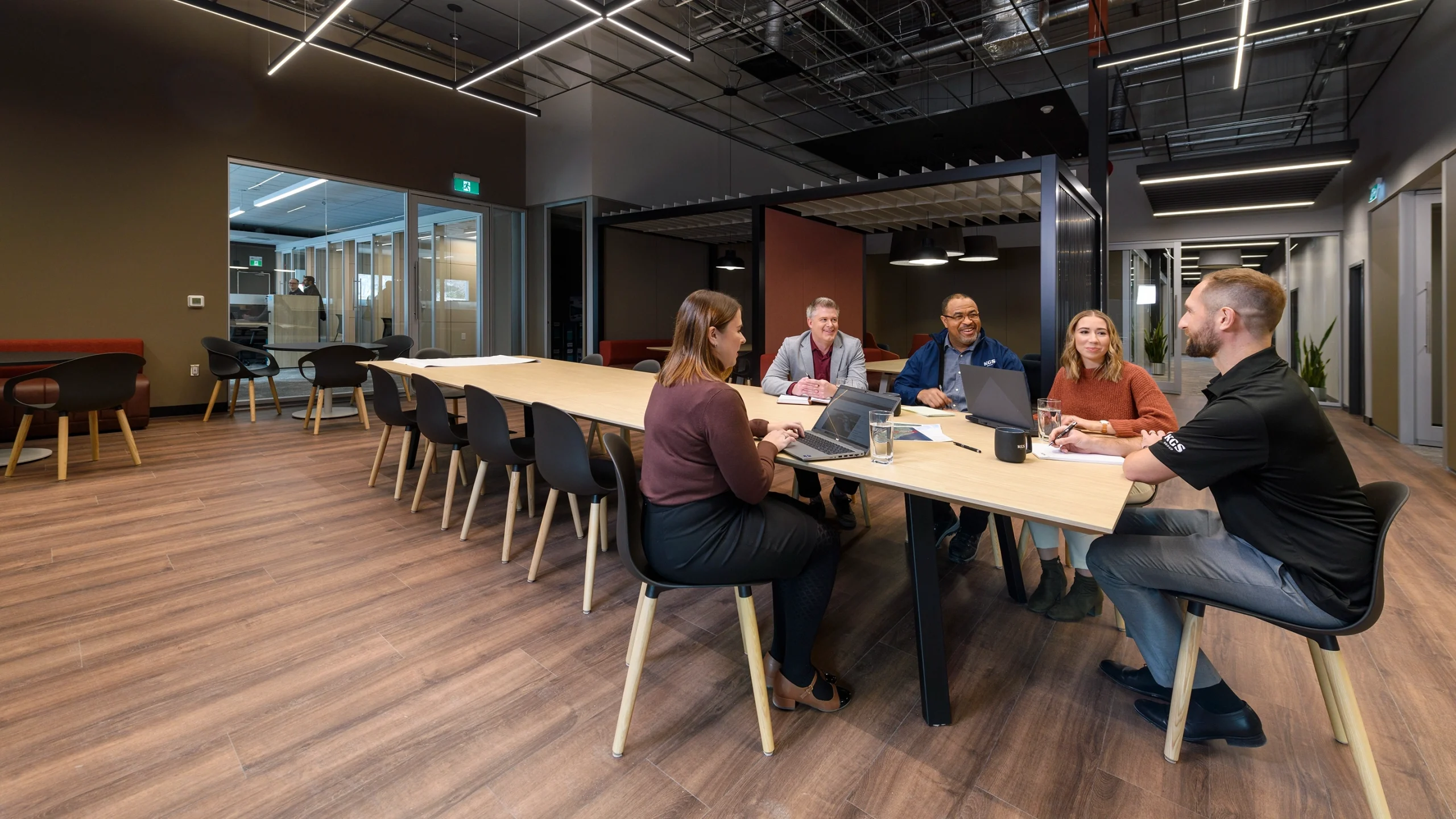 Five people discuss a project around a table