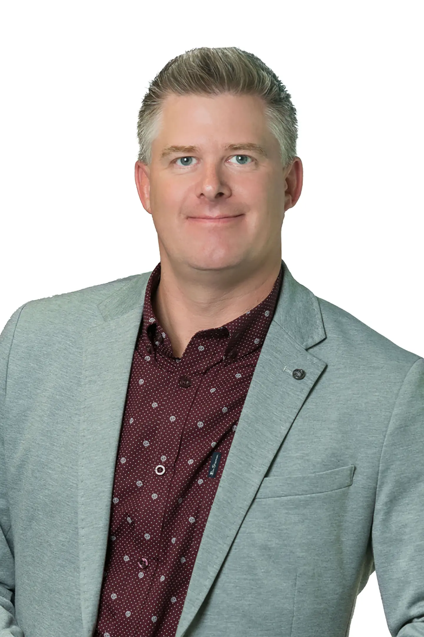 Professional headshot of a person smiling at the camera against a white background.