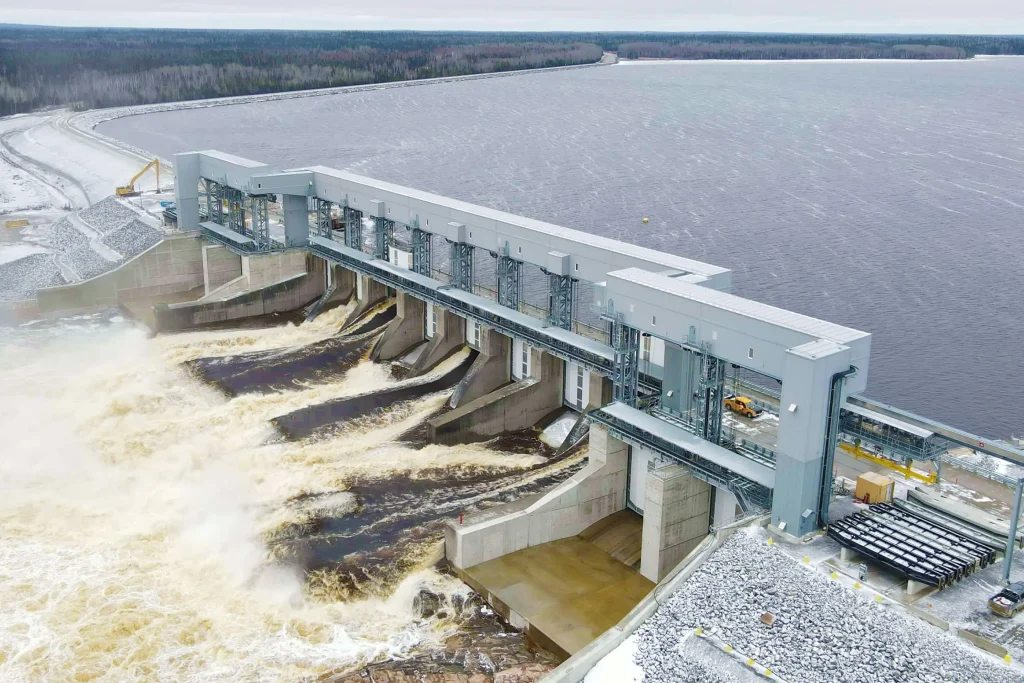 Hydroelectric dam in large body of water. Water rushing through the spillway.