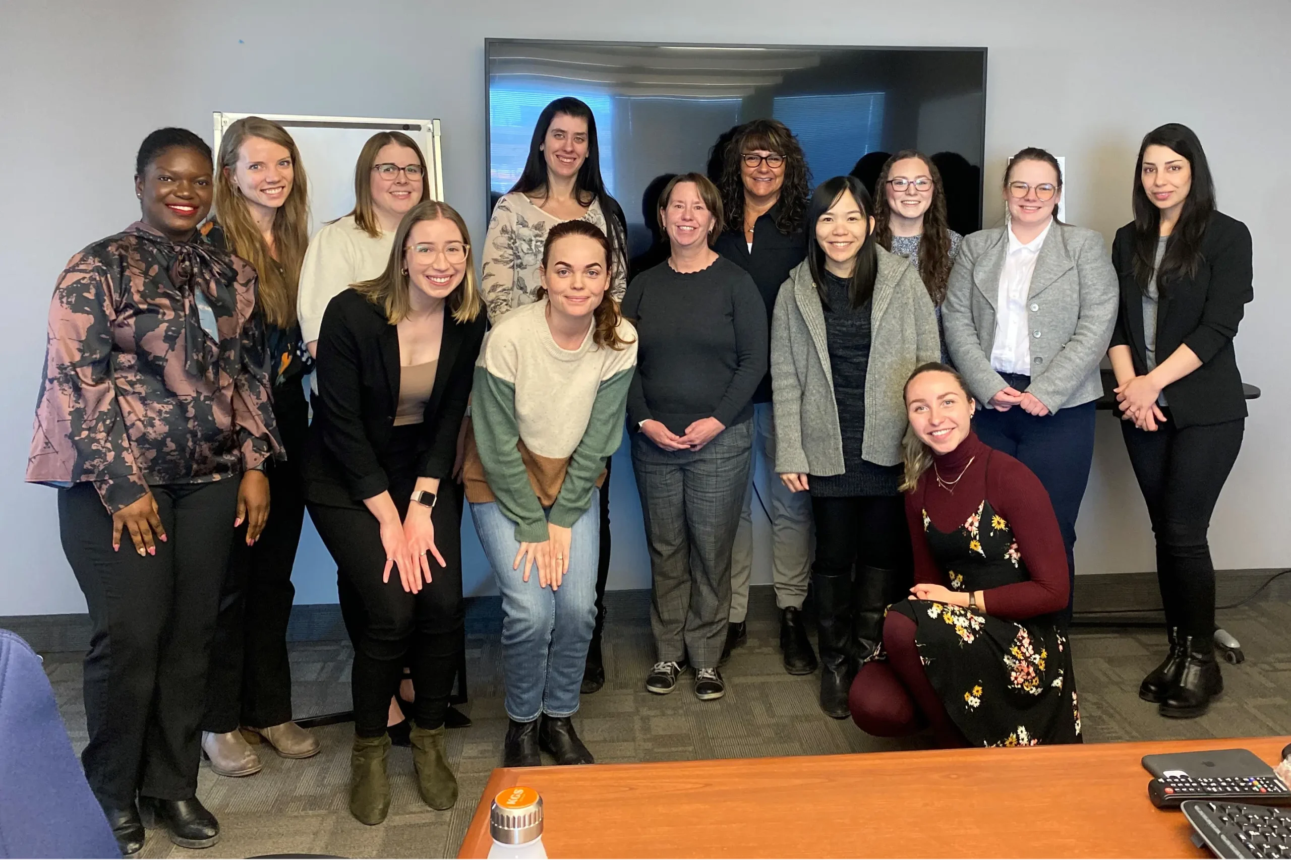 A group of women engineers gather for a photo in an office environment.