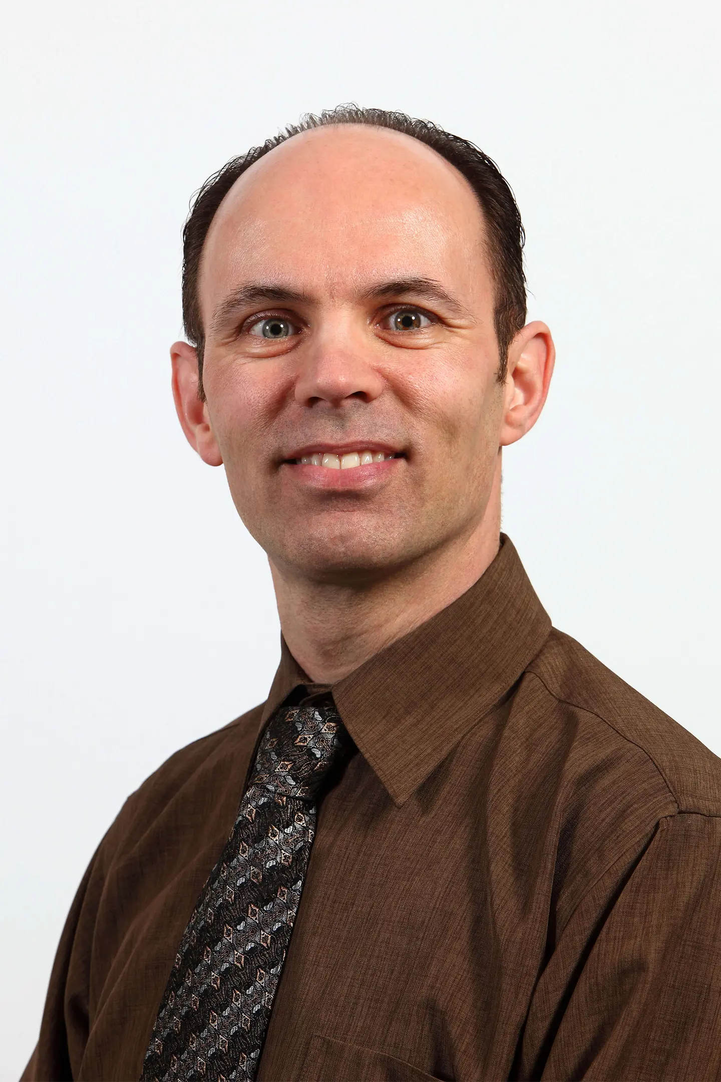 Professional headshot of a person smiling at the camera against a plain background.