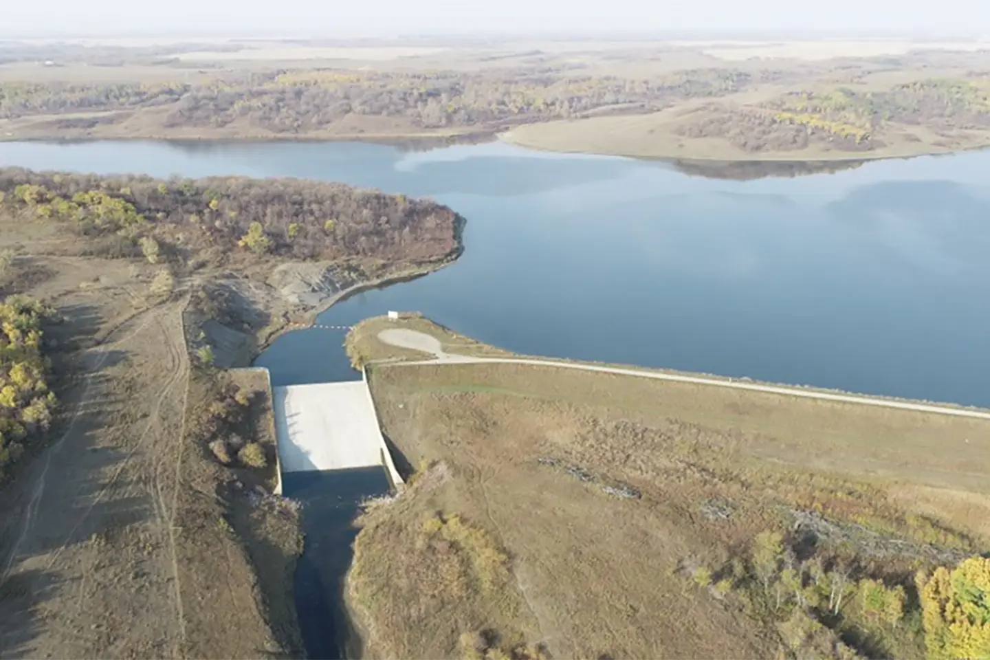 Aerial view of a large body of water surrounded by lush green forest.