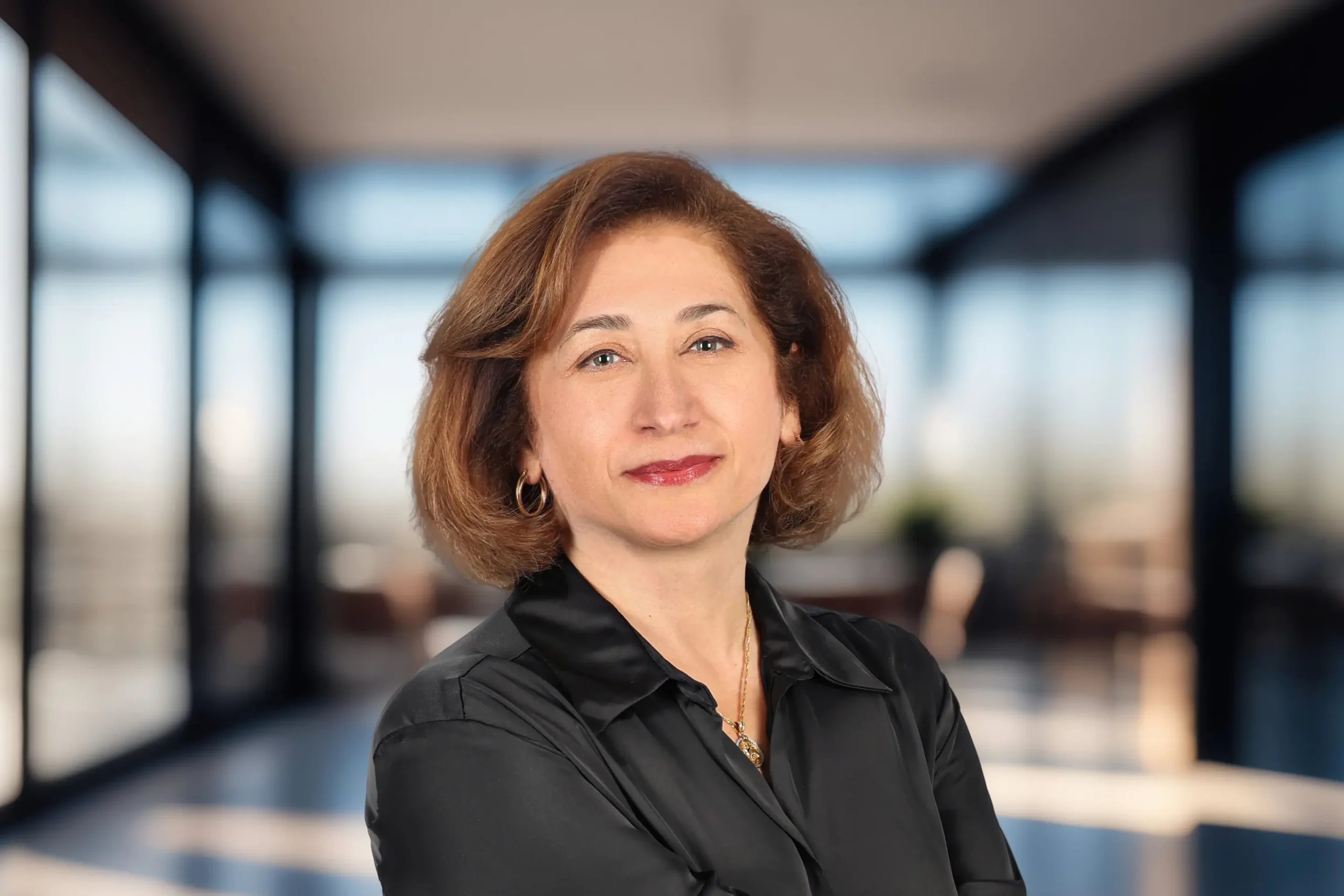 Pooya Shariatahmadi smiles confidently while posing in an office setting.