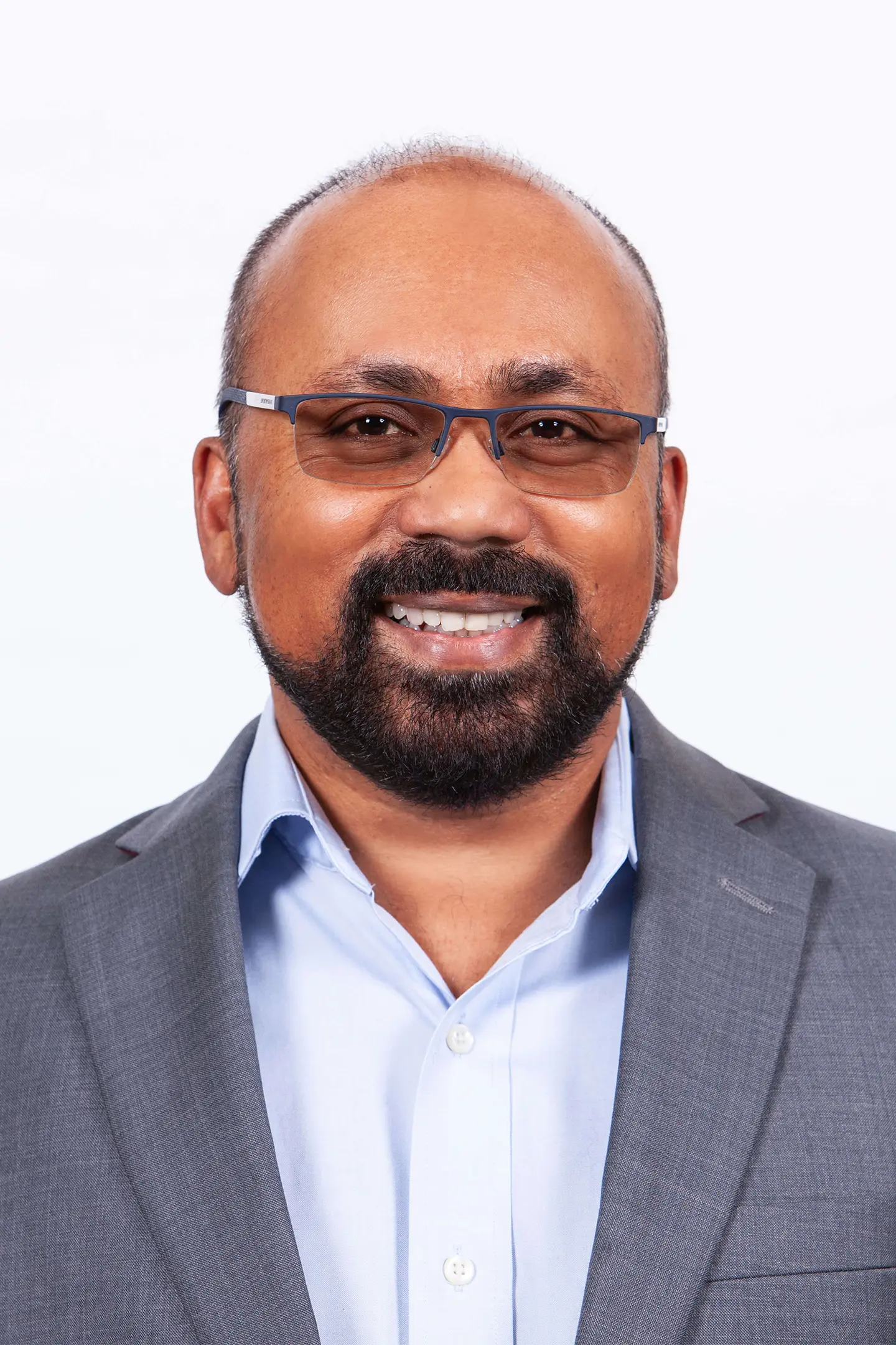 Professional headshot of a person smiling at the camera against a white background.