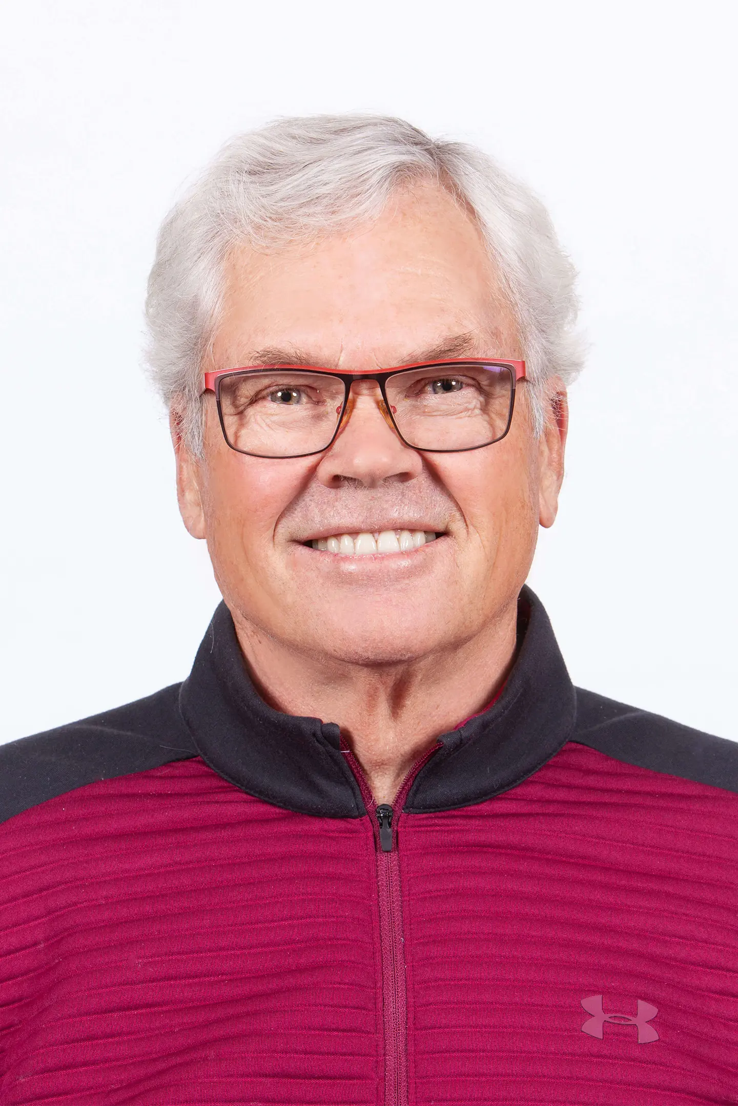 Professional headshot of a person smiling at the camera against a white background.