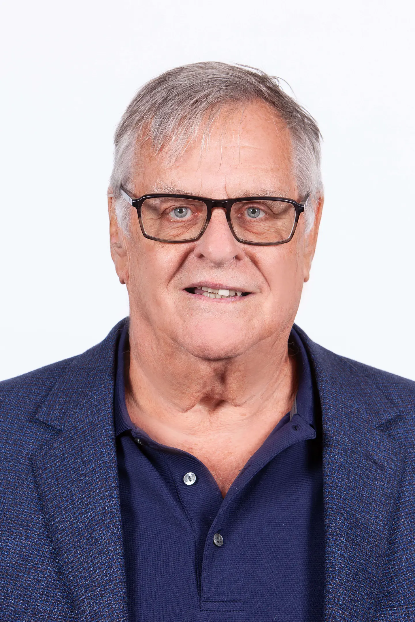 Professional headshot of a person smiling at the camera against a white background.