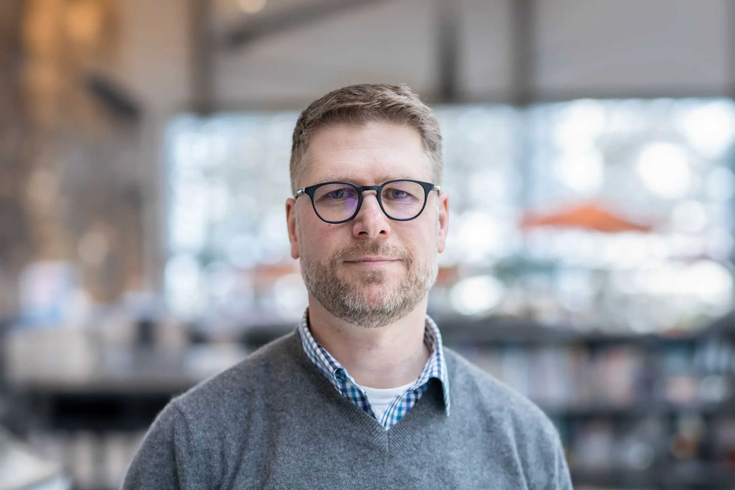 Stan Diachun smiles warmly while standing in an office setting.