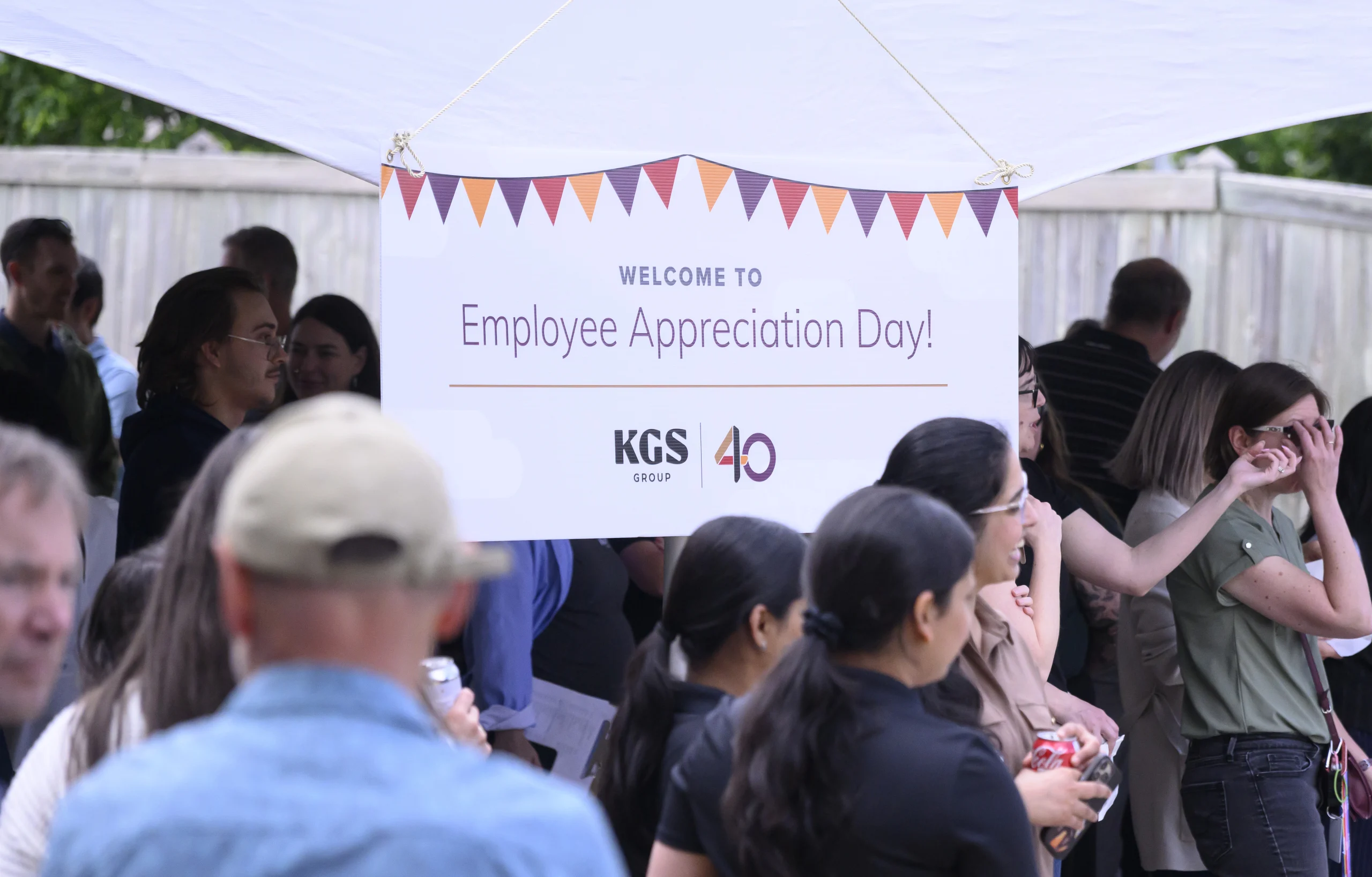 Employees standing before sign