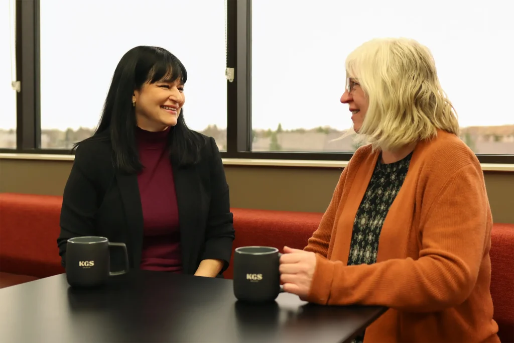 Women sitting at table holding coffee mug